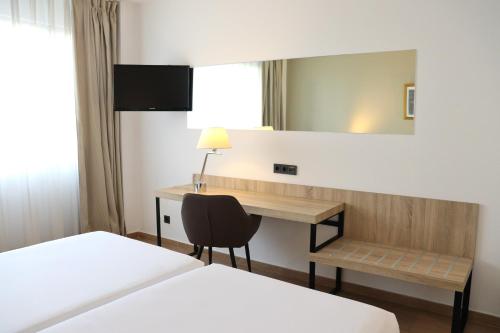 a hotel room with a desk and a bed at Eurohotel Diagonal Port in Barcelona
