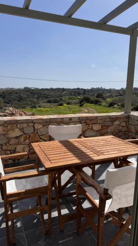 a wooden table and chairs on a patio at Aroniadika rooms in Kýthira