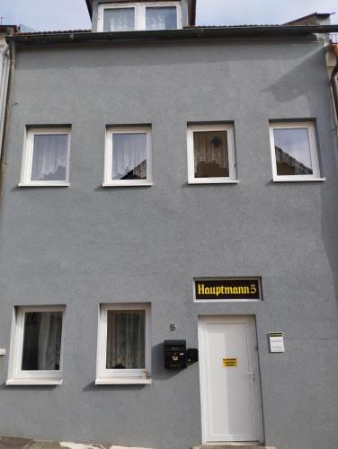 a gray building with a white door and windows at Hauptmann5 in Waldmünchen