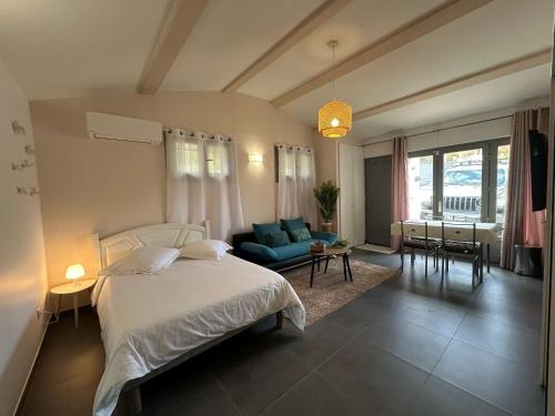 une chambre avec un lit et un canapé bleu dans l'établissement Studio calme et agréable avec acces jardin partage, à Le Bar-sur-Loup
