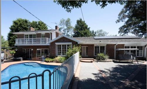 a house with a swimming pool in front of it at Paradise Holiday Home in Melbourne