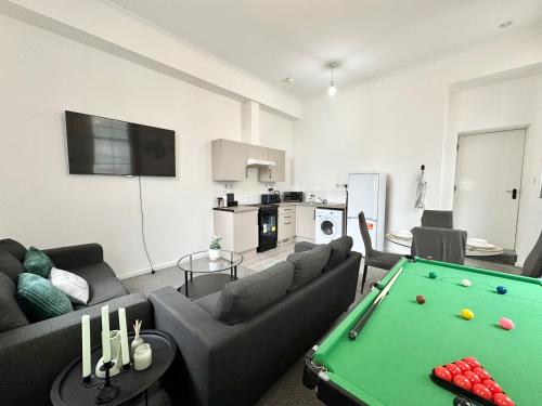 a living room with a couch and a pool table at City Haven - Modern 2 Bedroom in Sheffield in Sheffield