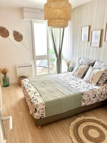 une chambre avec un lit et une grande fenêtre dans l'établissement Le Cocon, 100m de la plage, place de parking privé, à Saint-Hilaire-de-Riez