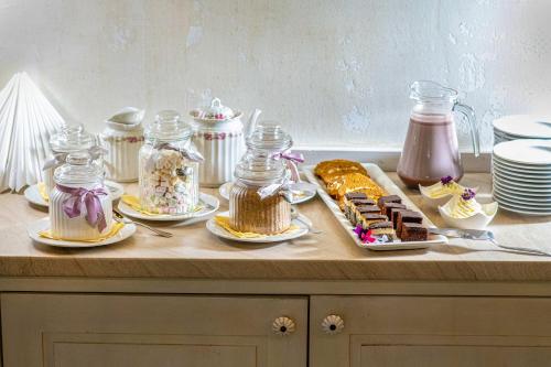 a table with cakes and desserts in jars on it at Boutique Hotel Szárcsa in Székesfehérvár