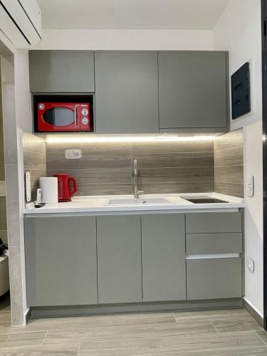 a kitchen with a sink and a microwave at Agora LX Studios & Suites in Thessaloniki