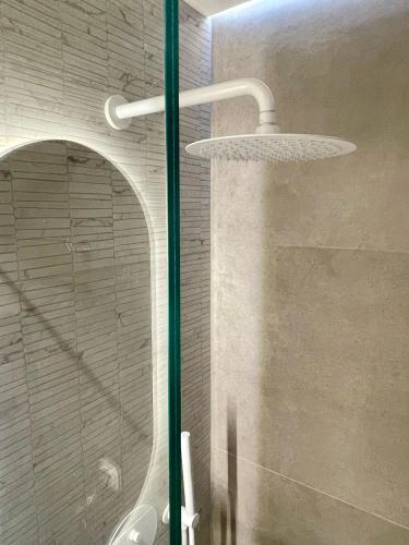 a shower with a shower head in a bathroom at Agora LX Studios & Suites in Thessaloniki