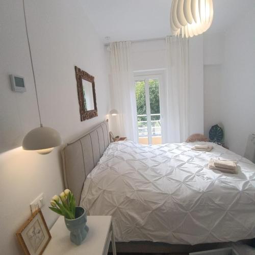a bedroom with a white bed and a window at Onda d'Oro in Finale Ligure