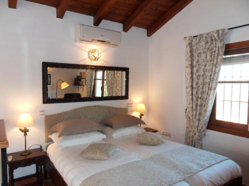 sypialnia z dużym łóżkiem z dużym lustrem w obiekcie Bed & Breakfast | Guest House Casa Don Carlos w mieście Alhaurín el Grande