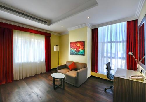 a living room with a couch and red curtains at Swiss-Belhotel Seef Bahrain in Manama
