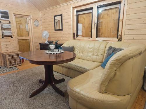 a living room with a couch and a table at Rentyny Rodzinny dom wypoczynkowy nad jeziorem in Rentyny