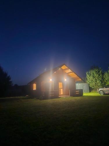 a house lit up at night with lights at Rentyny Rodzinny dom wypoczynkowy nad jeziorem in Rentyny