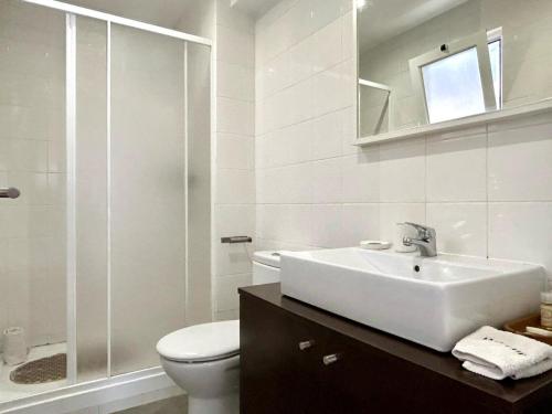 a white bathroom with a sink and a toilet at Studio Polvo in Parede