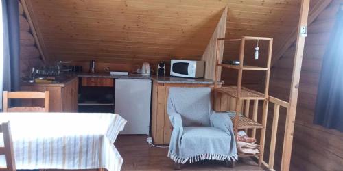 a small kitchen with a counter and a chair in a cabin at Rönkházacska - Kétkerék Vendégház in Mátraszentimre