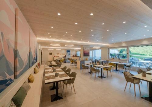 a dining room with tables and chairs in a restaurant at Hotel Funivia in Bormio