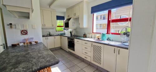 a large kitchen with white cabinets and a window at 26 Le Paradis in Ballito