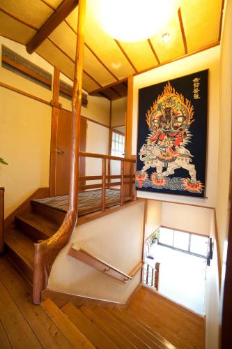 a room with stairs and a painting on the wall at Hinodeya in Ito