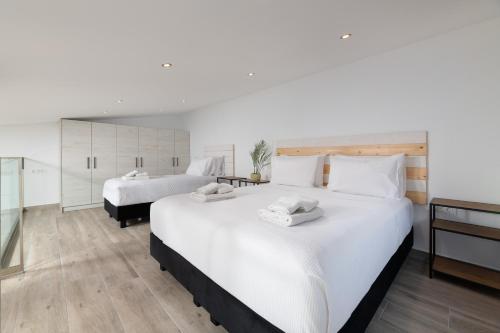 a large bedroom with two beds and a bathroom at Stone Apartments in Kremasti