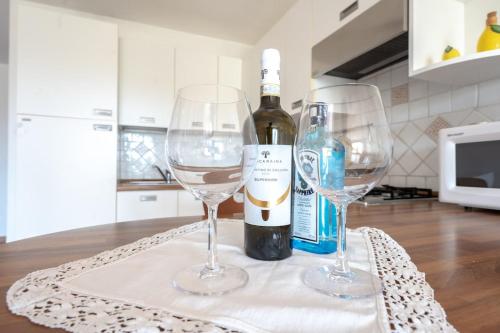 a bottle of wine and two wine glasses on a table at Perla Marina in Porto San Paolo