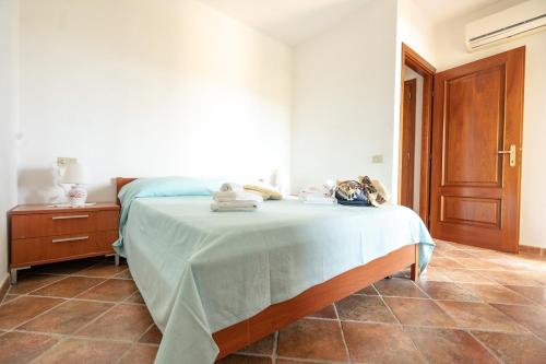 a bedroom with a bed with a blue blanket on it at Perla Marina in Porto San Paolo