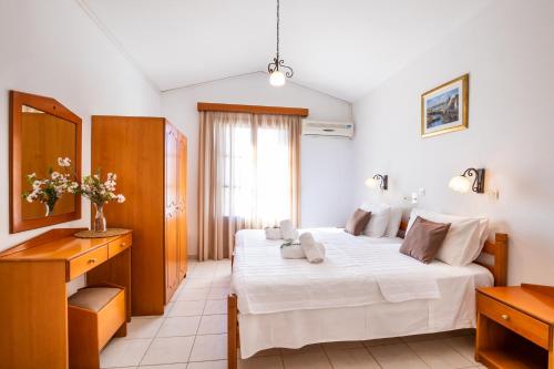 a bedroom with a large white bed and a window at Iliada Studios in Karpathos Town