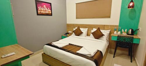 a small bedroom with a bed and a desk at Akshays Inn in Chengalpattu