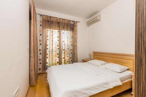 a bedroom with a white bed and a window at Sea View Apartments Perovic in Budva