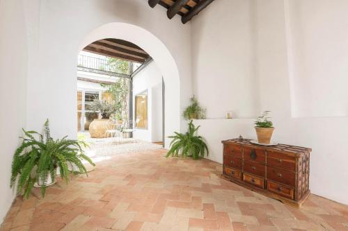 an arched hallway with a dresser and potted plants at Mar Abierto A in Sanlúcar de Barrameda