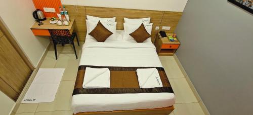 a bedroom with two beds and a table with a chair at Akshays Inn in Chengalpattu