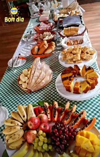 a long table filled with different types of food at Chalés Riacho da Serra Capitólio in Guapé