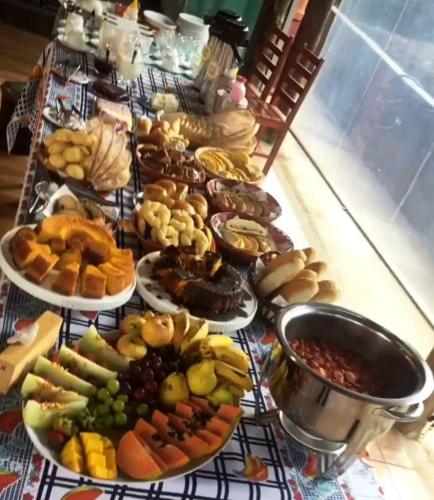 a table full of different types of food on plates at Chalés Riacho da Serra Capitólio in Guapé