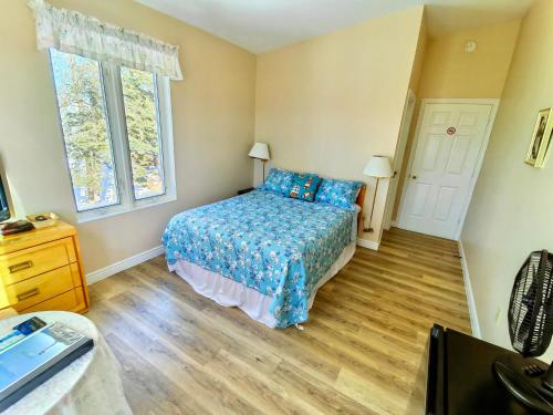 a small bedroom with a bed and two windows at 181 Oceanside Inn in Peggy's Cove