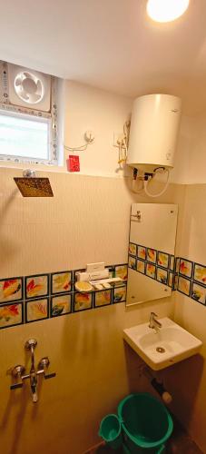 a bathroom with a sink and a toilet and a mirror at Akshays Inn in Chengalpattu