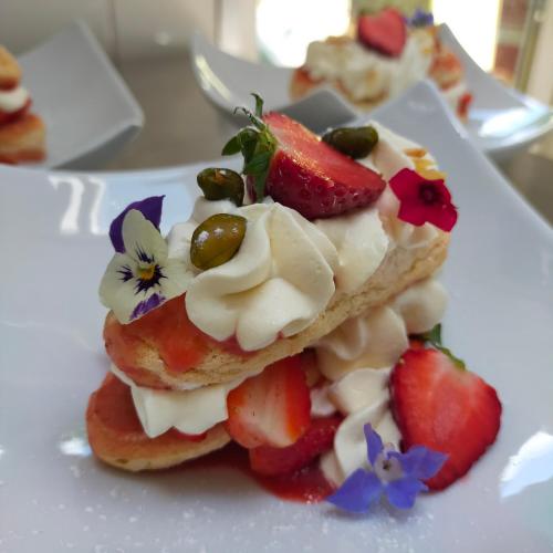 a piece of cake with fruit on a white plate at Hotel Les Alpes in Allevard