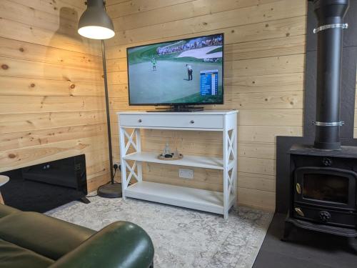 a living room with a tv and a stove at The Homestead Compact With private Lazy spa in Northbourne