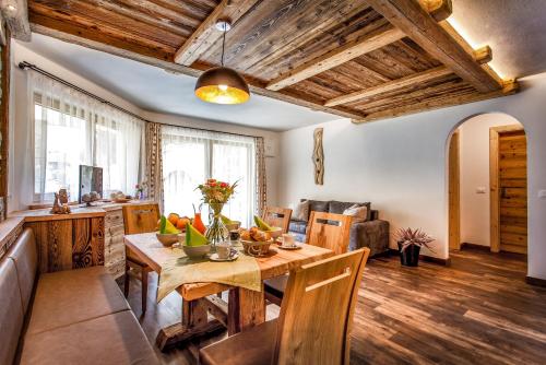 a kitchen and living room with a wooden table at Alpine Mountain Chalet in San Vigilio Di Marebbe