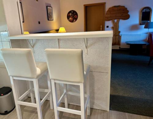 two white stools sitting at a bar in a room at Pension Raststüb'l in Sorge