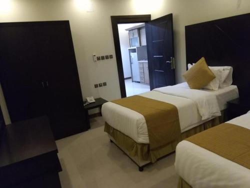 a hotel room with two beds and a doorway at 430 Guest House Residential Hotel in Islamabad