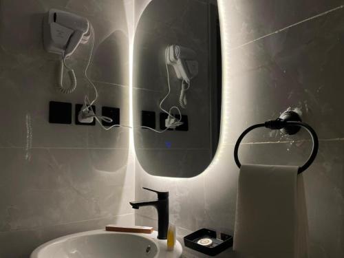 a bathroom with a sink and a mirror with a hair dryer at 430 Guest House Residential Hotel in Islamabad