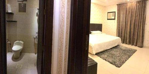 a bedroom with a bed and a bathroom with a toilet at 430 Guest House Residential Hotel in Islamabad