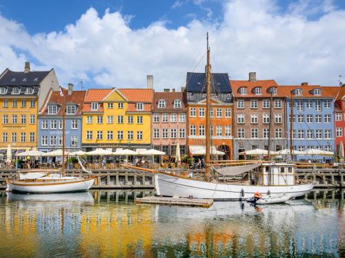 a group of boats docked in a harbor with buildings at Sanders Regent - Chic Three-Bedroom Apartment Near Central Square in Copenhagen