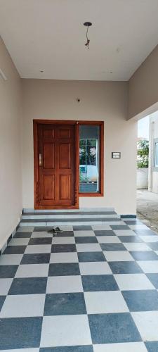 an empty room with a door and a checkered floor at Luxe Stays in Namunasamudram