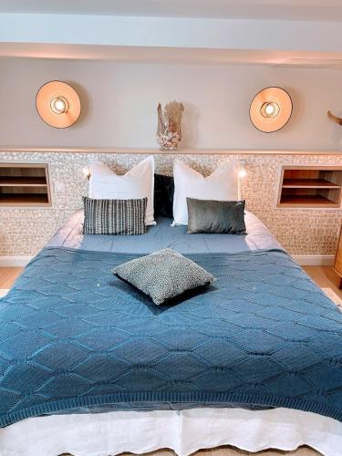 un grand lit avec une couette bleue dans une chambre dans l'établissement Peaceful Oasis in Ville d'Hiver, à Arcachon