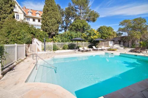 une grande piscine avec de l'eau bleue dans une cour dans l'établissement Villa Saint-Raphael, à Saint-Raphaël