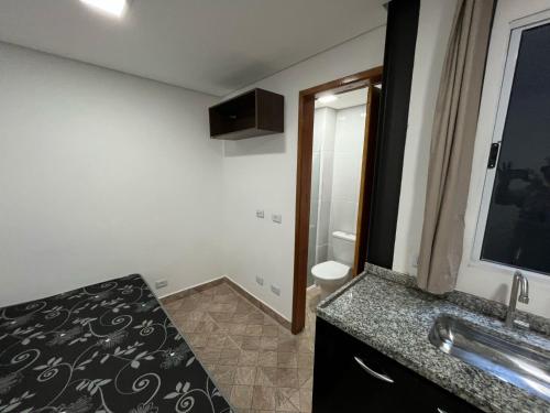 a bathroom with a sink and a toilet and a mirror at Condomínio Residencial Vitória 3 in Sao Paulo