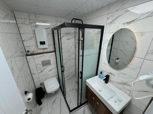 a bathroom with a shower and a sink and a mirror at Midyat Amaara Konağı Otel&Cafe in Midyat