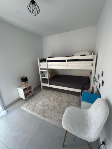 - une chambre avec des lits superposés blancs et une chaise dans l'établissement Superbe 3 pièces familiale, à Menton