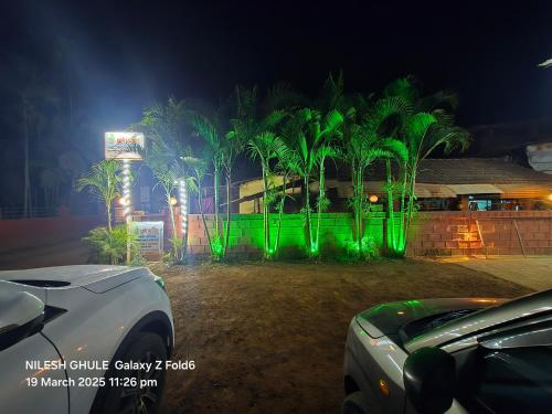 a group of palm trees with green lights at A Ghule Patil Family Beach in Diveagar