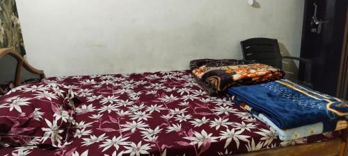 a bed with a red and white comforter at Hotel R K Palace in Rewa