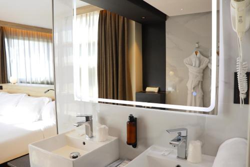 a bathroom with a sink and a mirror and a bed at Eurohotel Diagonal Port in Barcelona