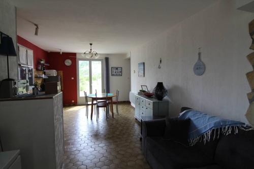 un salon avec un canapé et une table et une cuisine dans l'établissement Maison 3 pièces Oléron 6 couchages SAINT GEORGES D'OLERON SGO000-434, à Saint-Georges-dʼOléron